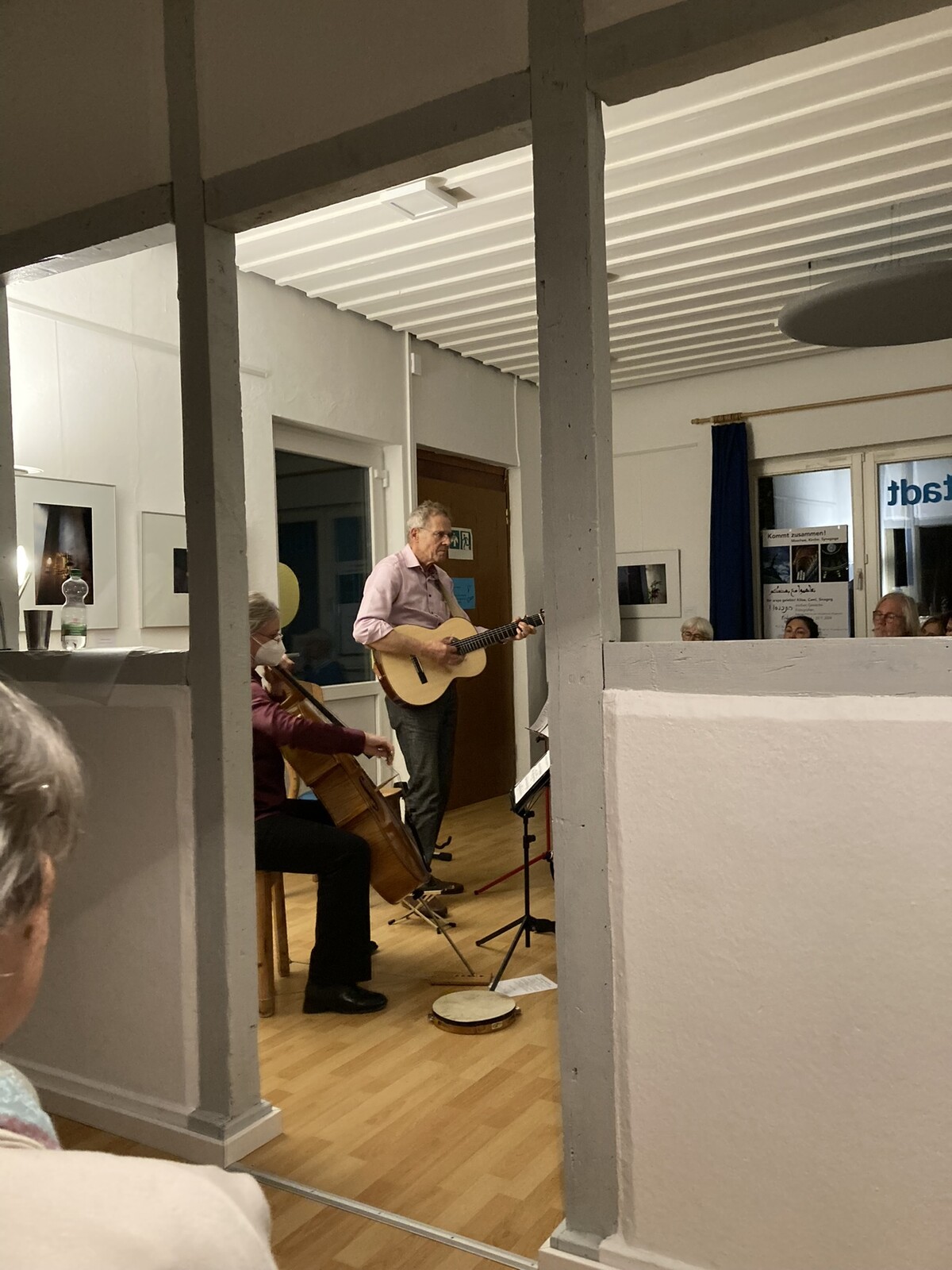 ein Sänger mit Gitarre und ein Chello mit verdecktem Spieler