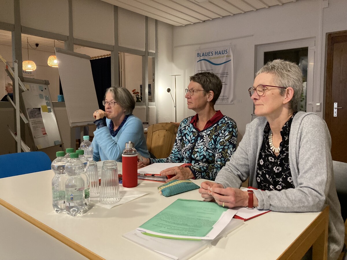 drei Frauen sitzen am Tisch und lauschen eienm Vortrag